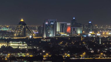 Deira bölgesindeki Dubai silueti ve şehir merkezindeki mimarisi. Şeyh Zayed yolu yakınlarındaki sayısız gökdelen ve alışveriş merkezinin havadan görüntüsü. Işıklı kuleler ve trafik