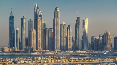 Dubai Marina ufuk çizgisi gün batımında, Palm Jumeirah, Dubai, BAE 'deki villalarla birlikte. Dubai 'nin bu kısmında 50 kattan fazla gökdelen var.