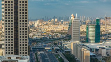 Dubai gökdelenlerinin zaman çizelgesi akşam vakti. Dubai metro istasyonu ve Şeyh Zayed Yolu 'ndaki trafik. Kule çatısından gökyüzü görüntüsü. Güzel bulutlu gökyüzü