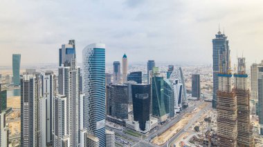 Dubai'nin iş bay önce günbatımı timelapse kuleleri. Çatı görünümü bazı gökdelenler ve yapım aşamasında yeni kuleleri. Trafik Kavşağı ile yolda. Bulutlu gökyüzü
