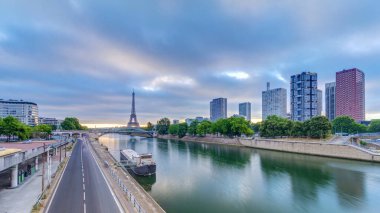 Eyfel Kulesi Seine Nehri 'nde ve Fransa' nın Paris şehrinde teknelerle renkli gündoğumu zamanı. Grenelle Köprüsü 'nden hava görüntüsü. Modern binalar ve yol trafiği. Dramatik bulutlar