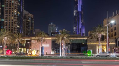 Dubai siluetinin timelapse ve acele saat trafik gece şehir merkezinde cadde görünümü. Avuç içi ve arka plan üzerinde modern kuleleri olan yol