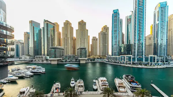 Modern binaları ve geleneksel tekne saatleri olan Dubai marinası. Günbatımı saatinde yukarıdan modern kulelerin en üst hava manzarası