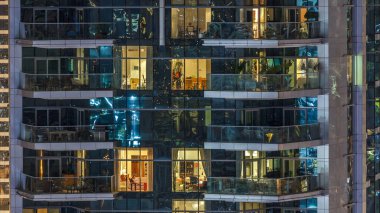 Akşam timelapse, gökdelenlerin doğal parlayan windows. Dubai Yat Limanı modern konut yüksek katlı binaların görünümü. Daire içinde hareket insanlar. Hava Üstten Görünüm.