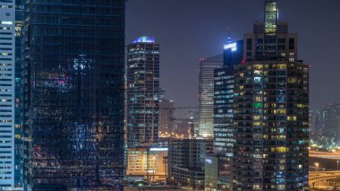 Dubai Yat Limanı gece timelapse, Glittering ışıklar ve en yüksek gökdelenler. Işıklı kuleleri ve arka plan üzerinde yolda trafik