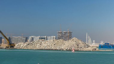 Kazı makinesi Palm Jumeirah zaman çizelgesinde yeni bir bölüm oluşturuyor. Liman terminali inşaatı. Arka planda Dubai silueti