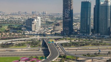 Bir büyük şehir timelapse bir yol kavşak hava görünümünü. Arabalar ve gökdelenler ile UAE Dubai Yat Limanı bölgesinin kentsel peyzaj.