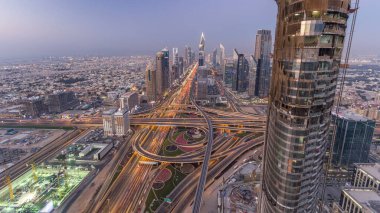 Dubai şehir merkezindeki ufuk çizgisi günden geceye geçiş zamanı. Şeyh Zayed kavşağındaki çok sayıda aydınlatma kulesiyle çatıdaki trafiğin görüntüsü.