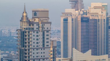 Gün batımında inanılmaz renkli Dubai marinası ve JLT silueti. Çoklu en uzun gökdelenlerin büyük perspektifi. Binaların üzerinde güneş ışığı. Birleşik Arap Emirlikleri.