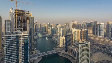 Gün batımı timelapse sırasında inanılmaz renkli dubai marina manzarası. Dünya Yat ve tekne ile birden fazla en yüksek gökdelenler, büyük bakış açısı. Binalar üzerinde güneş ışığı. Birleşik Arap Emirlikleri.