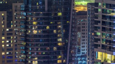 Akşam timelapse, gökdelenlerin parlayan windows. Dubai Yat Limanı modern konut yüksek katlı binaların görünümü. Daire içinde hareket insanlar. Hava üstten görünüm.