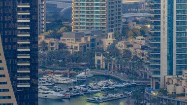 Promenade ve lüks gökdelenler ve yatlar çevresinde timelapse, Birleşik Arap Emirlikleri Dubai Marina kanal. Gün batımı sırasında hava üstten görünüm