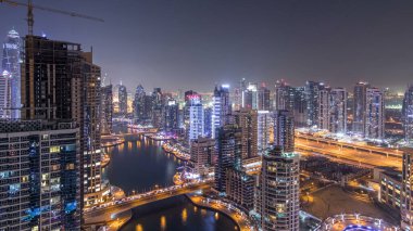 Dubai Yat limanı manzarası, gece timelapse üzerinde su kanalı. Konut kuleleri aydınlatma ve aydınlatma ile. Yat ve tekne trafiği olan gökdelenler yüzen