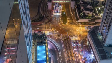 Bir büyük şehir gece timelapse bir yol kavşak hava görünümünü. Yaş ve gökdelenler ve tramvay hattı ile UAE Dubai Yat Limanı bölgesinin kentsel peyzaj.