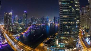 Dubai Yat limanı manzarası, gece timelapse üzerinde su kanalı. Konut kuleleri aydınlatma ve aydınlatma ile. Yat ve tekne trafiği olan gökdelenler yüzen