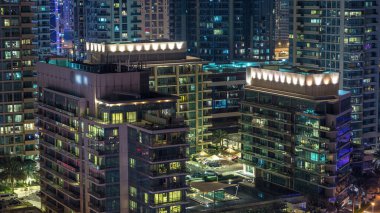 Konut kuleleri aydınlatma ve aydınlatma timelapse ile. Yol ve Dubai Yat Limanı ve Jlt manzarası, gece güvertede. Rating gökdelenler ile parlayan pencere eşiği yanında
