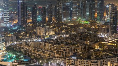 Dubai şehir gece timelapse modern ışıklandırılmış gökdelenler, alışveriş merkezi ve yolda trafik ile. Üstten üstten görünüm