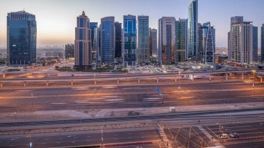 Jumeirah lakes hava görünümünü gün geçiş timelapse Şeyh zayed road ve metro hattı üzerinde trafik ile gecesine ışıklandırılmış gökdelenler ile kuleleri. Dubai Yat Limanı güneş doğmadan önce çatı görünümü