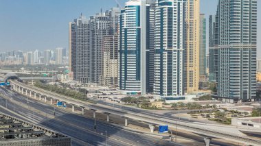 Jumeirah göl kulelerinin ve barsha gökdelenlerinin hava görüntüsü Şeyh zayed yolunda ve metro hattında trafik var. Gün batımında uzun gölgeler ve camlarda yansımalar