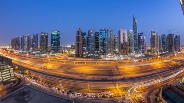 Jumeirah göl kulelerinin hava manzarası gökdelenler günden geceye geçiş zamanı Sheikh zayed yolu ve metro hattı trafiği.