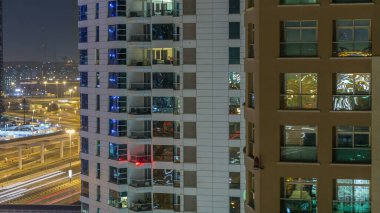 Windows çok katlı binanın içinde aydınlatma ve insanlar timelapse içinde hareketli çelik ve cam. Dubai Yat Limanı modern konut gökdelenlerin havadan görünümü.