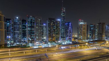 Jumeirah göl kulelerinin gökdelenleri aydınlık gece görüşü Şeyh zayed yolu ve metro hattı yakınlarındaki kavşakta trafik vardı. Dubai marinasından çatı manzarası
