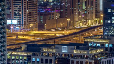 Sheikh Zayed karayolu hava timelapse üzerinde yoğun bir kavşak üzerinde gece trafik. Dubai şehir merkezinde çatı üzerinden görüntülemek