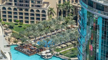 Dubai şehir merkezi zaman çizelgesi, lüks modern binalar ve palmiyelerle çevrili yüzme havuzu, Birleşik Arap Emirlikleri 'nin gelecekteki şehirleri. Gökdelenden gökyüzü görüntüsü