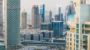 Akşam Dubai şehir merkezi ve finans bölgesi, Şeyh zayed yolundaki lüks modern binalar parlak sarı günbatımı ışığı ve gölgeler, fütürist şehir manzarası. Gökdelenden gökyüzü görüntüsü