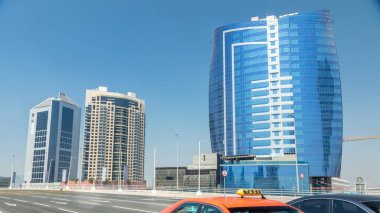 Dubai 'nin panoramik iş sahası ve şehir merkezi manzarası. Güneşli bir günde modern gökdelenler ve mavi gökyüzü. Rıhtımdaki gezinti güvertesinden bak