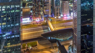 Sheikh Zayed Road ve DIFC gece timelapse Dubai, BAE binaların görünümünü manzarası. Finans merkezi metro istasyonu ile yukarıdan havadan görünümü içinde ışıklandırılmış gökdelenler