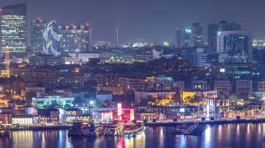 Dubai deresi gece manzarasını tekneler, yatlar ve yollarda trafik olan modern binalarla aydınlattı. Yukarıdan hava üstü görünümü