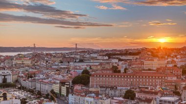 Lizbon, gün batımında, Portekiz 'in sonbahar akşamında şehir merkezinin kırmızı çatılı manzarası. Arkaplanda köprü var. Miradouro da Nossa Senhora do Monte bakış açısından üstten görünüm