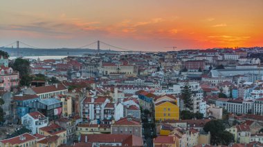 Lizbon gün batımında şehir merkezinin panoramik manzarasında sonbahar akşamında kırmızı çatılar, Portekiz. Sophia de Mello Breyner Andresen 'in bakış açısı. Turuncu gökyüzünde güneş