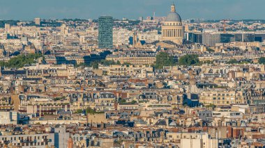 Paris 'teki evlerin çatılarının üstündeki hava manzarası. Güneş batmadan önce pantheon kubbesi ve gökdelenle akşam manzarası