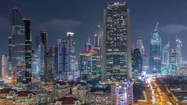 Dubai'de şehir merkezi ve finans bölgesine havadan görünüm, ışıklı gökdelenler ve otoyollar ile Birleşik Arap Emirlikleri.