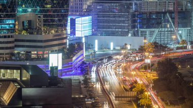 Al Saada caddesinde, Dubai, BAE 'deki DIFC gece zaman çizelgesi yakınlarındaki kavşak trafiğinin Skyline görüntüsü. Finansal merkezdeki aydınlık gökdelenler şehir merkezinin yukarısından gökyüzü manzarası