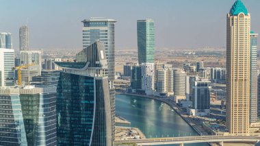 Gün batımından önce gökdelenler zaman aşımına uyarak Dubai'nin iş koyu hava silueti. Yukarıdan modern kuleler ve kanal