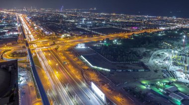 Şeyh Zayed yol ve kavşak gece timelapse, Dubai, Birleşik Arap Emirlikleri trafiğe havadan görünümü. Metro hattı ve evler
