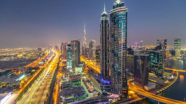 Dubai, Bae gece geçiş timelapse için şeyh zayed yol gün modern gökdelenler ve trafik ile Akşam silueti. İş koyu mimarisinin havadan görünümü.