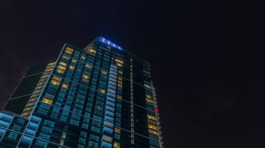 Gece Gökyüzü, modern gökdelenlerin üzerinde bulutlar parlayan pencereler, mimari zaman çizelgesi. İş merkezi