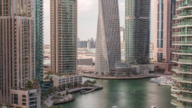 Dubai Marina yerleşim ve ofis gökdelenlerinin deniz manzarası. Yüzen tekneler ve yatlar