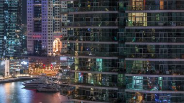 Dubai Marina yerleşim ve ofis gökdelenlerinin deniz kıyısına bakan zaman aralıklı görüntüsü. Yüzen tekneler ve yatlar