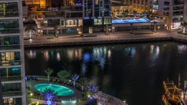 Dubai Marina Havuzu 'nda yüzme havuzlu bir rıhtım gezisi. Kanalda yüzen tekne ve yatlar. Dubai, Birleşik Arap Emirlikleri