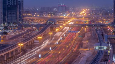 Dubai Marina 'dan Şeyh Zayed yoluna gece gündüz aydınlık gökdelenlerle geçiş zamanı, Dubai. Tramvayı olan trafik, köprüler ve metro istasyonları. Birleşik Arap Emirlikleri