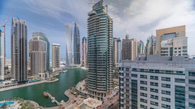 Dubai Marina konutlarının ve sahil manzaralı ofis gökdelenlerinin panoramik görüntüsü. Yüzen tekneler ve yatlar