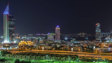 Dubai medya kenti aydınlatılmış gökdelenler ve golf sahası gece timelapse, Dubai, Birleşik Arap Emirlikleri. Yolda trafik ile Yeşiller bölgesinden havadan görünüm
