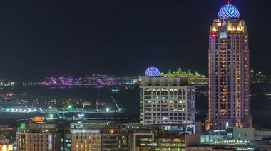 Dubai medya kenti aydınlatılmış gökdelenler ve golf sahası gece timelapse, Dubai, Birleşik Arap Emirlikleri. Yolda trafik ile Yeşiller bölgesinden havadan görünüm