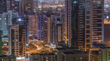 Tecom ilçe gökdelenler Yeşiller ilçe gece timelapse havadan görünümü. Ofis ve konut aydınlatmalı binalar yukarıdan.