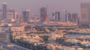 Göller timelapse ile Golf sahası yakınındaki evler ve villalar için havadan görünümü. Jumeirah köy daire ilçesinde Şantiye. Sıcak akşam ışığı